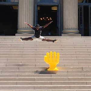 Handshake hand chair outside Gorgas Library with jumping student