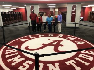 Employer Advisory Board members pose in front of the UA logo in the locker rooms at the Mal Moore Athletic Facility